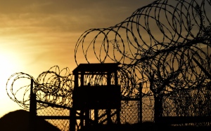 This photo made during an escorted visit and reviewed by the US military, shows the razor wire-topped fence and a watch tower at the abandoned 